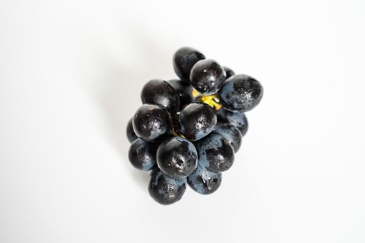 A Bunch of Black Grapes against a plain white background