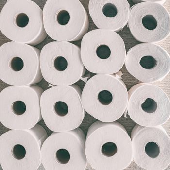 Toilet paper rolls background top flat view of many open rolls, square crop.