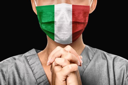 Praying for Italy. Coronavirus pandemic outbreak in Italy. Doctor praying for help. Young woman medical doctor surgeon or nurse portrait.