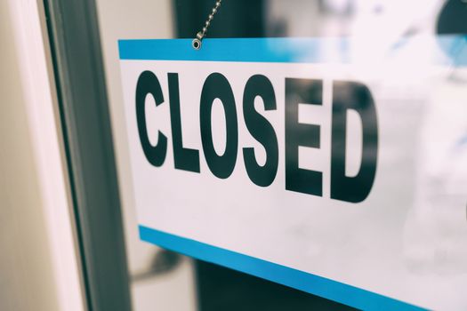 Closed sign on retail business store window because of COVID-19 Pandemic outbreak. Government shutdown of restaurants, shopping stores, non essential services.