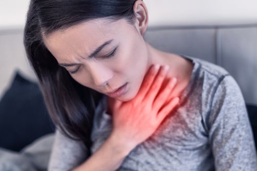 COVID-19 Corona virus symptoms are pneumonia, shortness of breath, fever, body aches or breathing difficulties. Asian woman sick of Coronavirus with red area showing pain.
