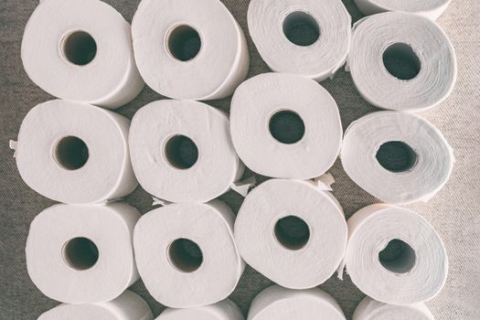 Toilet paper rolls background top flat view of many open rolls. Hoarding of bathroom tissues in fear of store supply shortage during coronavirus COVID-19 panic buying.