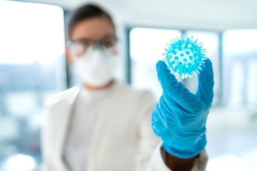 Coronavirus lab research woman researcher finding vaccine cure holding corona virus blue model of COVID-19.