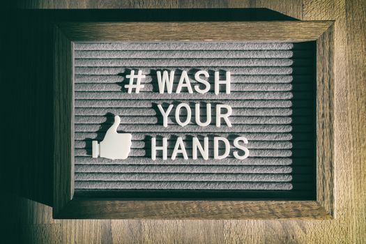 COVID-19 hand hygiene coronavirus message social media text for washing your hands hashtag. Corona virus felt board sign with letters WASH YOUR HANDS.