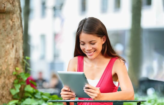 Online remote work Asian young woman on social distancing meeting remotly for work conference using tablet pc computer in garden outdoor. COVID-19 technology worker.