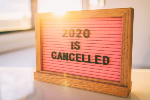 COVID-19 Funny Quote on pink felt sign board: 2020 IS CANCELLED message at home.