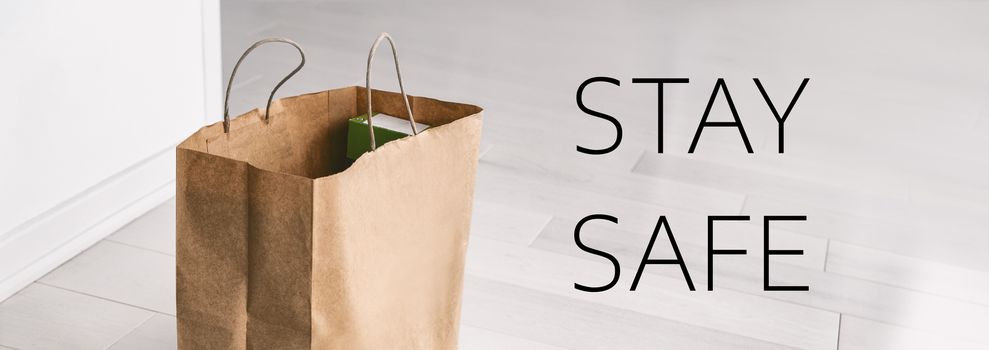 Home delivery STAY SAFE banner sign during Corona virus COVID-19 contactless online shopping. Grocery bag at entrance door panoramic.