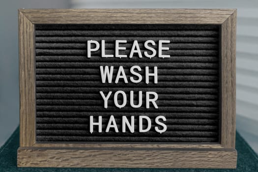 COVID-19 washing hands coronavirus spreading prevention message of handwashing hand hygiene corona virus text for washinghands.BLACK board sign with letters PLEASE WASH YOUR HANDS.