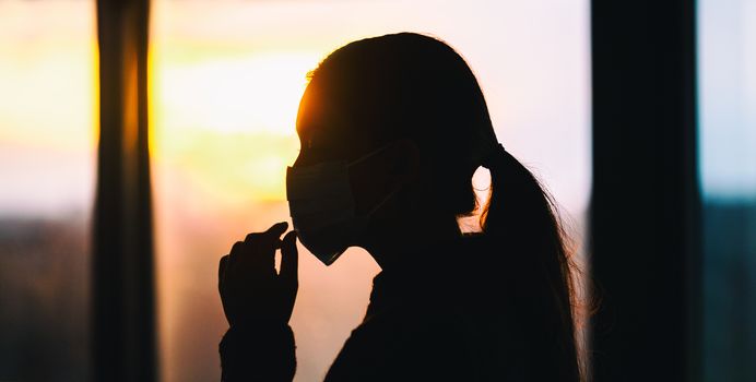 Coronavirus mask woman touching her medical surgical mask with hands. COVID-19 prevention advice : don't touch your face improper use of masks. Banner.