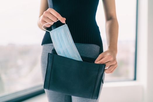 COVID-19 Prevention woman bringing medical mask in her purse for walking outside doing errands in public spaces and store. Coronavirus face masks protection obligatory wear to work.