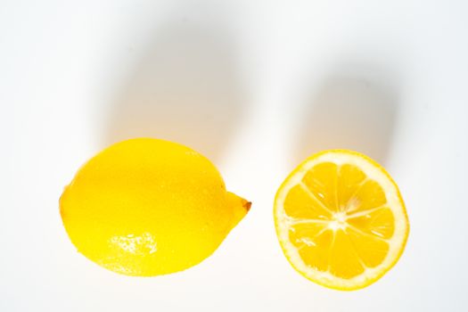A whole lemon and a half against a plain white background