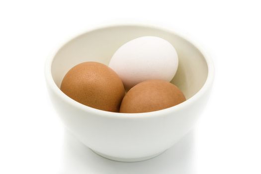 Brown and white eggs in a bowl isolated on white background