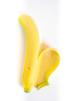A Whole banana with the skin peeled back against a plain white background