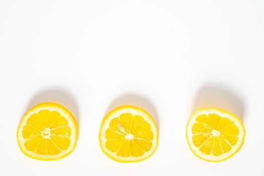 Three slices of lemon in a row against a plain white background