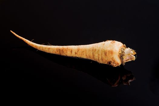Parsley root on a black surface