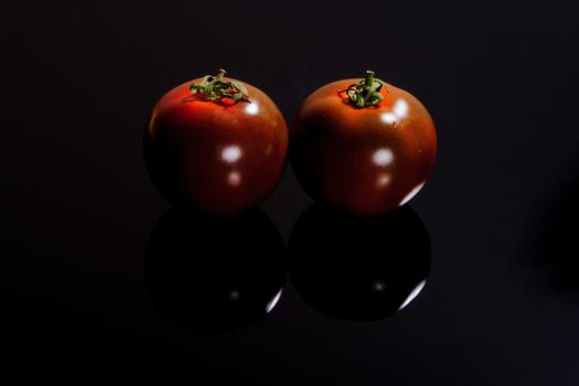 Dark tomatoes on a black surface