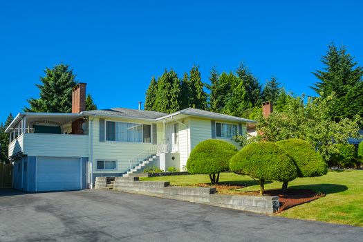 North american family house with asphalt driveway and stairway to the entrance.