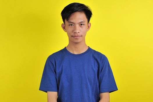 Portrait of young Asian man with confident smiling, isolated on  yellow