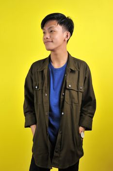 Confidence Asian young man wear casual t-shirts and jacket, isolated on yellow background