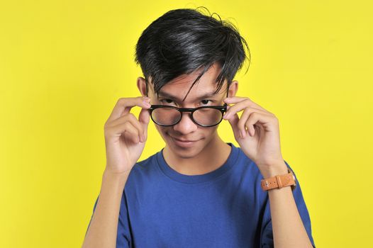 Close up portrait of attractive stylish charming confident, holding eyelets with hands, isolated on yellow background