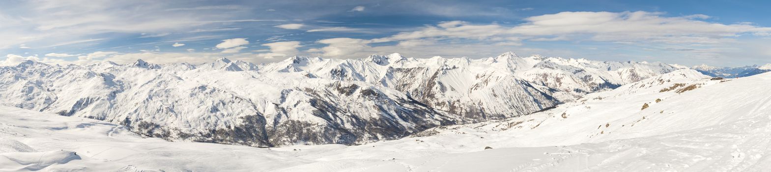 Panoramic view down a snowy mountain range valley in winter