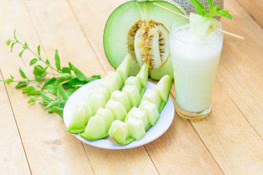 Fresh green melon on wood plate