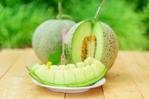 Fresh green melon on wood plate