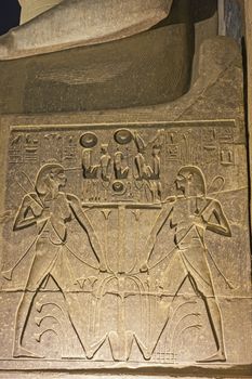 Large hieroglyphic carvings on wall at ancient egyptian Luxor Temple lit up during night background wallpaper