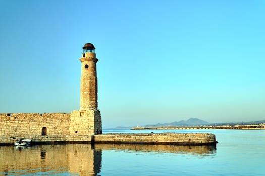 stone wall and historic lighthouse in the port of Rethymnon on the island of Crete