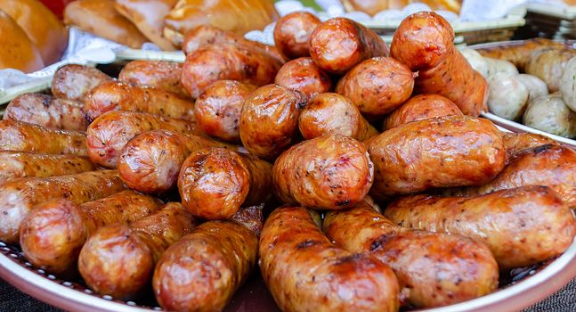 Grilled sausages with spices and herbs close-up