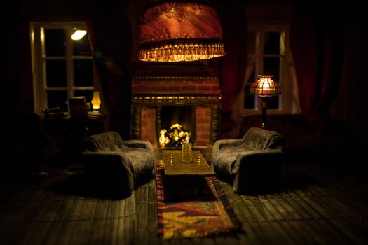 A realistic dollhouse living room with furniture and window at night. Artwork table decoration with handmade realistic dollhouse. Selective focus.