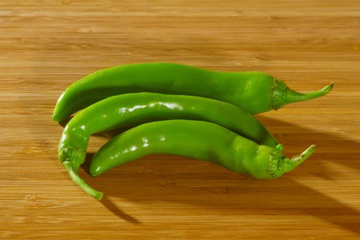 Green Chili Peppers on a wooden background