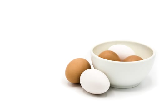 Brown and white eggs in a bowl isolated on white background