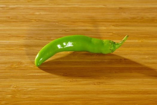 Green Chili Pepper on a wooden background