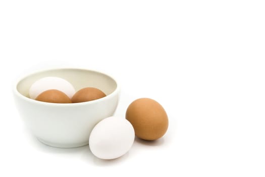 Brown and white eggs in a bowl isolated on white background