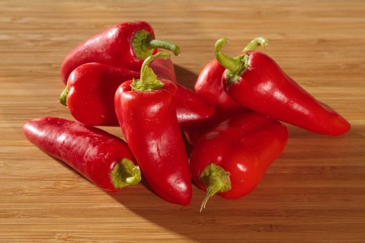 Small red peppers on a wooden background