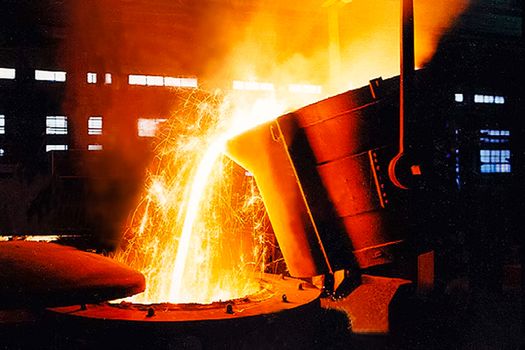 A large bowl of molten metal at a steel mill. Steel production.