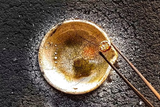 Melting the slag into a piece of gold. Melting gold in a fireproof cup.