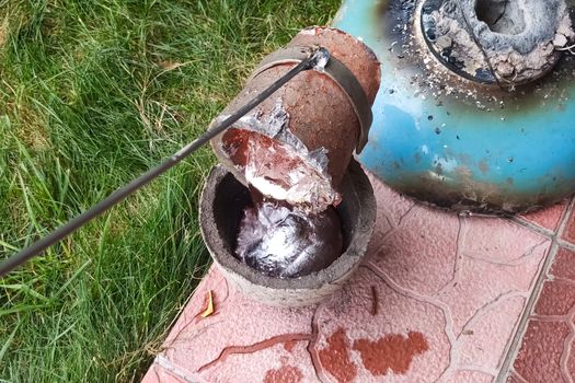 Melted metal in a fireproof cup taken from the oven. Melting copper at home.