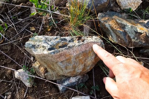 rock stone containing gold. A man's hand and a stone.