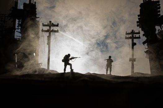 Army sniper with large caliber rifle standing in the fire and smoke. War Concept. Battle scene on war fog sky background, Fighting silhouettes Below Cloudy Skyline at sunset. City destroyed by war