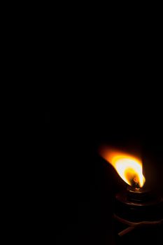 The flame of a black oil lamp