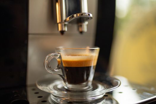 Espresso machine at home - coffee drink in glass cup ready in minute for flavor lovers