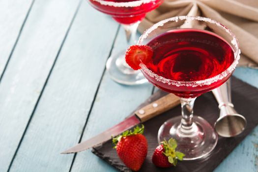 Strawberry cocktail drink in glass on blue wooden table