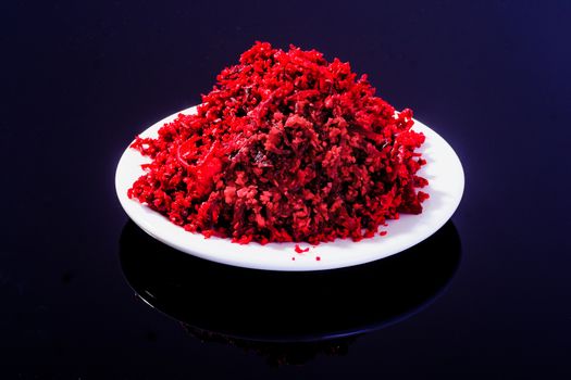 Horseradish sauce (with beet) - A traditional Jewish Passover dish. In a white plate on black background