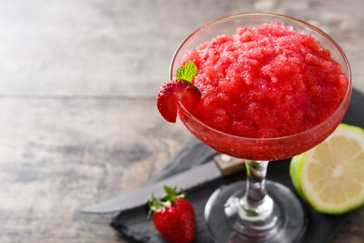 Strawberry margarita cocktail in glass on wooden table