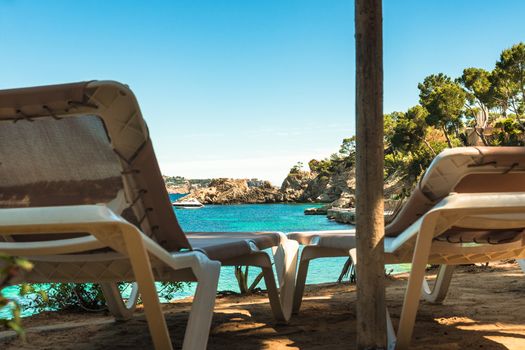 Idyllic sea view from two sun chairs of beautiful bay beach of Cala Fornells on Mallorca island, Mediterranean Sea Spain 