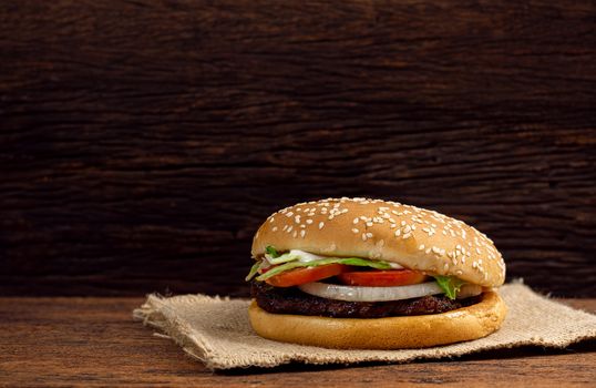 Hamburger meat and vegetables on wooden background