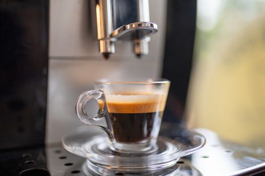 Espresso machine at home - coffee drink in glass cup ready in minute for flavor lovers