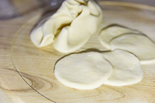 selective focus at circle shape pieces cut out from the dough for dumplings